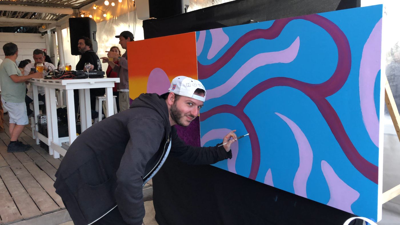 Artiste en live painting sur une toile bleue, juin 2022